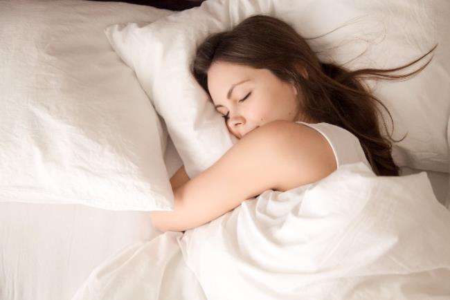 אישה צעירה ישנה שנת לילה טובה בשל הרכב מיקרוביום תקין במערכת העיכול